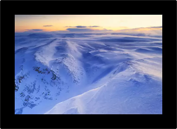 Fresh snow shaped by the cold Arctic wind blowing over mountains at dawn, Tana