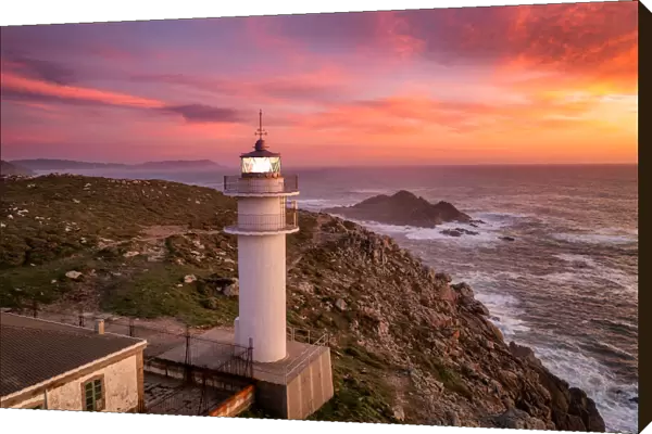Aerial sea landscape view of Cape Tourinan Lighthouse at sunset with pink clouds, Galicia