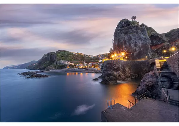 Dusk lights over the seaside town resort of Ponta do Sol washed by the ocean