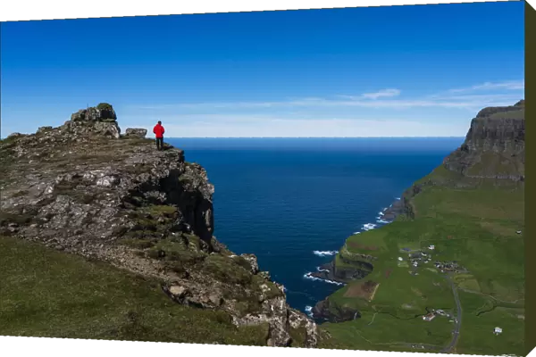 Hiker on The Postmans Trail to the village of Gasaldur, Vagar Island, Faroe Islands, Denmark, Europe