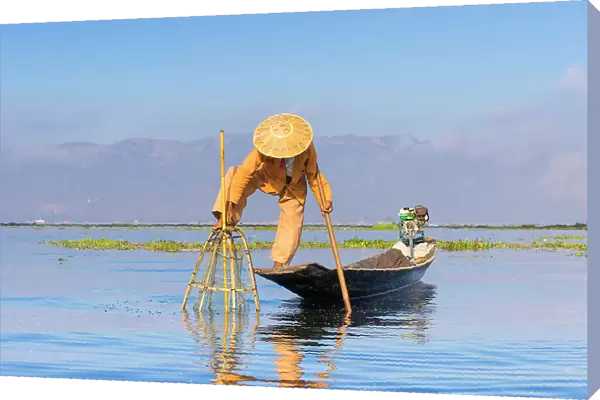 Fisherman with traditional conical net on boat, Lake Inle, Shan State, Myanmar (Burma), Asia