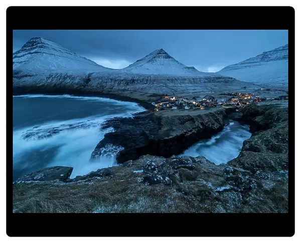 Gjogv village and snow covered mountains at dusk, Gjogv, Eysturoy Island, Faroe Islands, Denmark, Europe