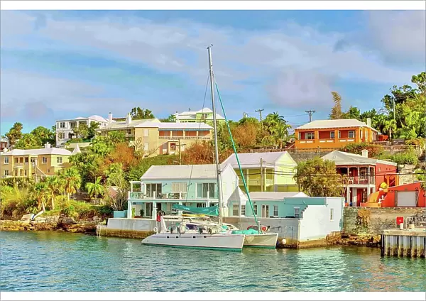 Catamaran in The Great Sound, moored in front of typical pastel coloured properties, Bermuda, Atlantic, North America