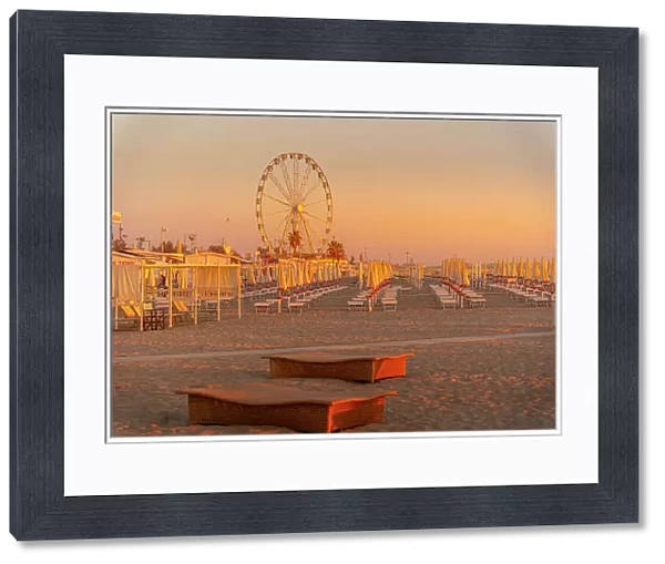View of ferris wheel and sunshades on the Lido on Rimini Beach at sunrise, Rimini, Emilia-Romagna, Italy, Europe