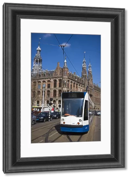 Modern tram with the Magna Plaza building behind, Amsterdam, Netherlands, Europe