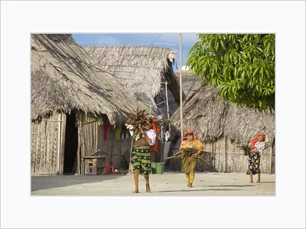 Kuna women carrying wood through village, Wichub-Wala Island, San Blas Islands