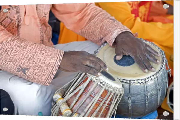Hindu musician playing the tabla (drums) with typical black spot made from a mixture of gum