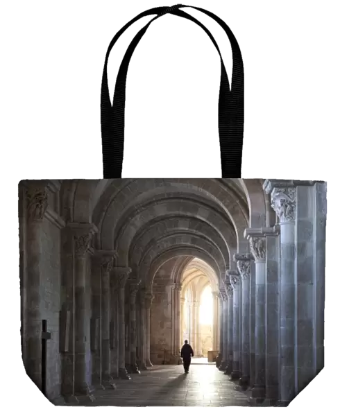 Interior north nave aisle with priest walking away, Vezelay Abbey, UNESCO World Heritage Site