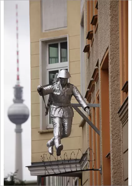 Berlin Television Tower (Fernsehturm) and sculpture of a soldier jumping the Berlin Wall at Bernauerstrasse, Berlin
