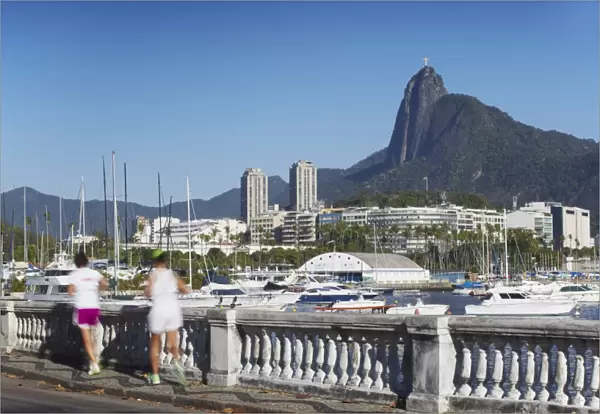 People jogging with Christ the Redeemer statue in background, Urca, Rio de Janeiro, Brazil, South America