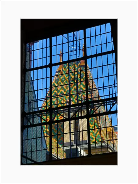 Traditional tiled roof seen through a metal framed window in Budapest, Hungary
