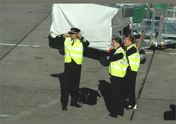 Aer Arran flight crew protecting hearing whilst standing on tarmac at Cork Airport, Ireland