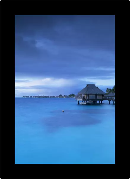 Overwater bungalows of Le Maitai Hotel and Intercontinental Bora Bora Le Moana Resort at dawn