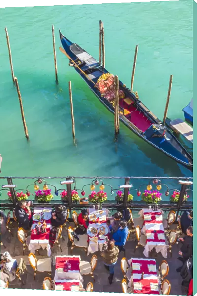 Venice, Veneto, Italy. Tourists eating out on the riverside of the Grand Canal