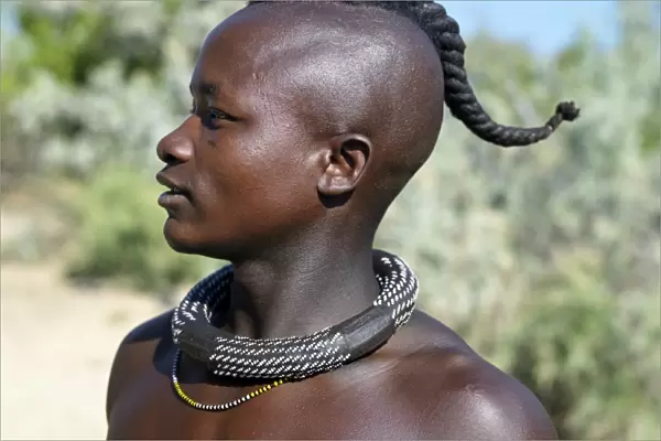 A Himba youth with his hair styled in a long plait, known as ondatu