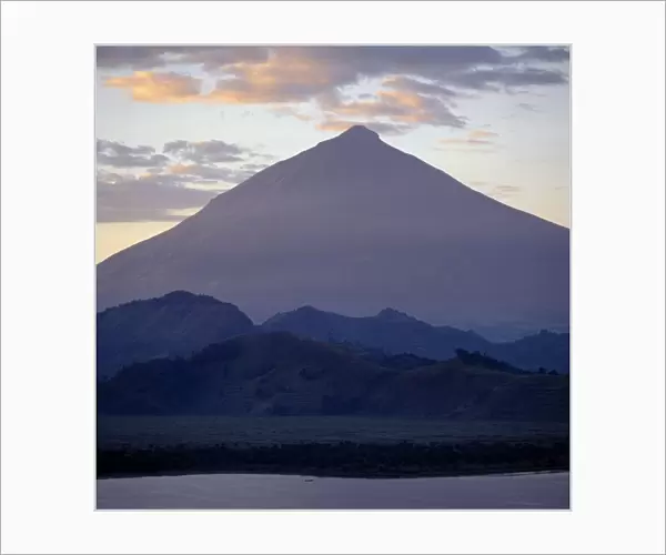 Photographed from Lake Mutanda at sunrise, Mount Muhavura looms like a huge pyramid