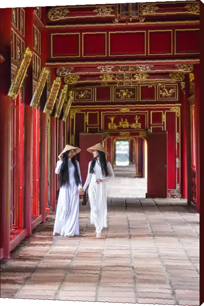 Two young women wearing traditional national costume, ao dai, in the Imperial City