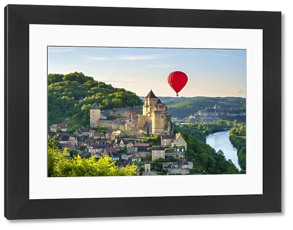 Hot-air balloon over Chateau de Castelnaud castle and Dordogne River valley in late