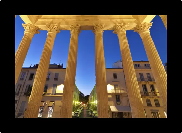France, Provence, Nimes, Maison Caree, View through pillars at night
