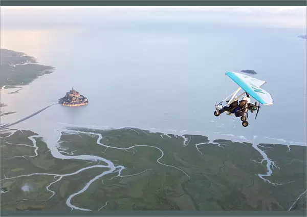 aerial view of Mont Saint Michel and Ultra light aircraft at high tide, Manche, France
