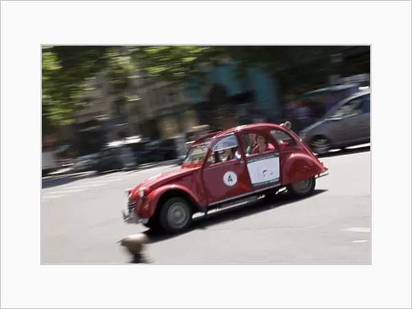 Tourists taking a tour of Paris in an old Citroen car with a retractable roof