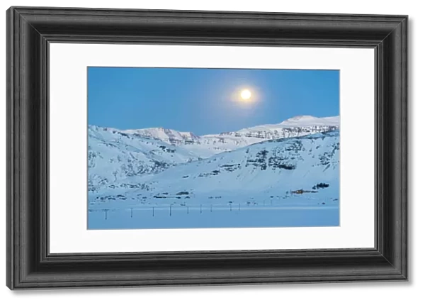 Iceland, Europe. Lonely house on the mountains in a winter landscape with full moon