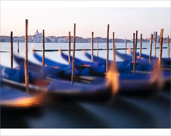 Traditional Venetian gondolas and mooring poles at dawn, Venice, Veneto region, Italy