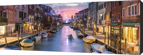 Italy, Veneto, Venice, Murano island. Canal at sunset with Christmas lights hanging