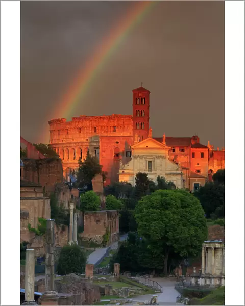 Italy, Rome, rainbow over Colosseum and Roman Forum at sunset