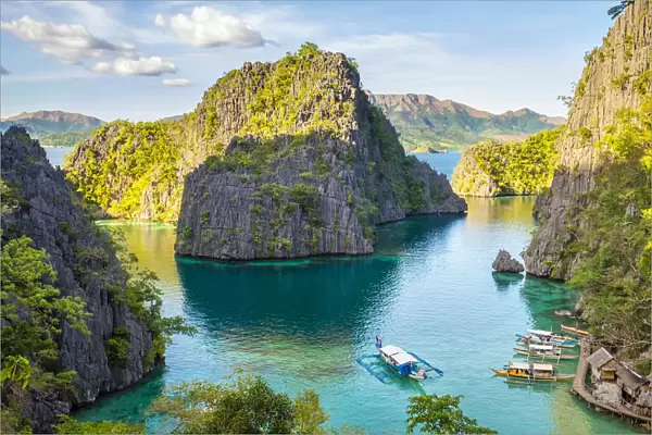 Outrigger boats and small village in a rocky inlet on Coron Island, Coron, Palawan