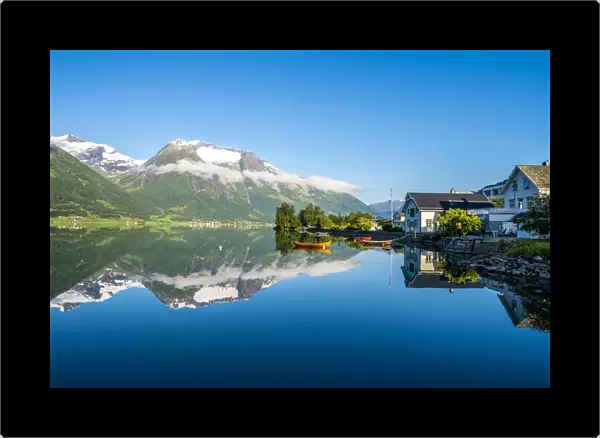 Village of Hjelle and mountains mirrored in Oppstrynsvatn lake, Oppstryn