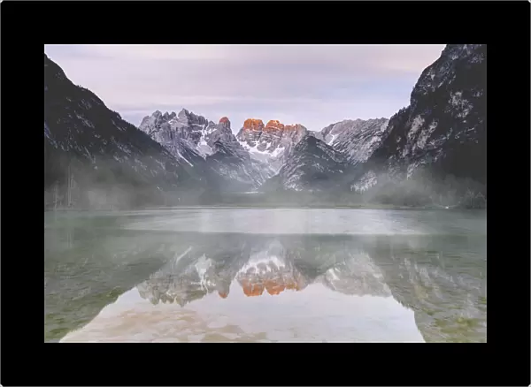 Cristallo and Popena group reflecting in lake Landro during a misty sunset, Dolomites