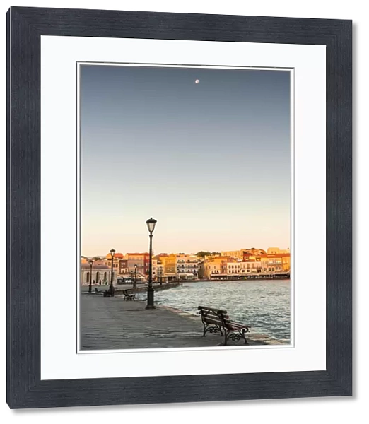 Bench on waterfront in the old Venetian harbour of Chania at dawn, Crete island, Greece