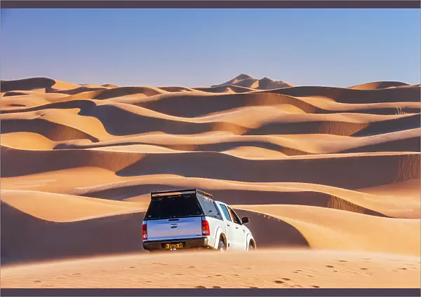 Namibia, Walvis Bay, a jeep driving on the san dunes of the Namib desert towards Sandwich Harbour