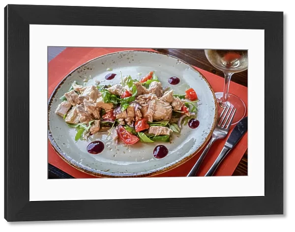 Italy, Tuscany, Elba. Seafood dish of wild tuna fish salad acompanied by a glass of Ansonica wine