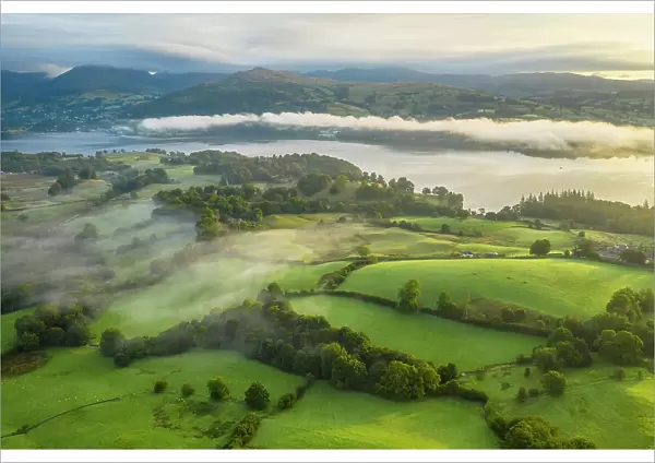 Aerial view of rolling countryside near High Wray, with Lake Windermere in the distance, Lake District National Park, Cumbria, England. Autumn (September) 2022