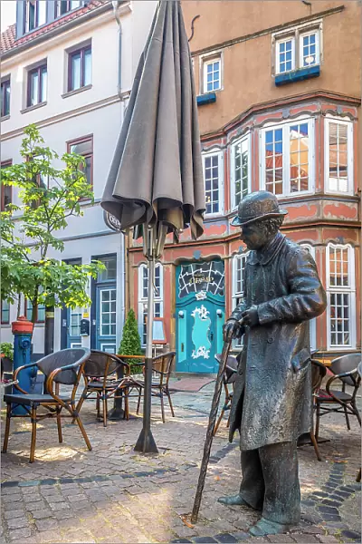 Bronze statue Heini Holtenbeen at street cafe in the historic Schnoor district, Bremen, Germany