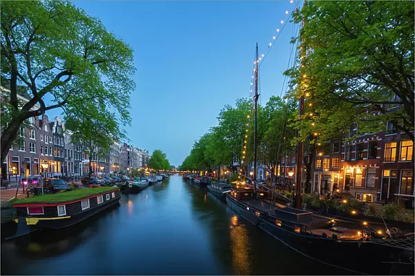 Boats and houses along Brouwersgracht canal at twilight, De Wallen, Amsterdam, Netherlands