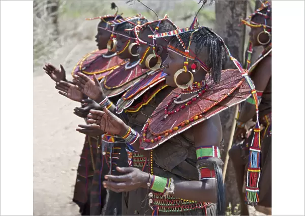 Pokot women wearing traditional beaded ornaments and brass earrings denoting their married status