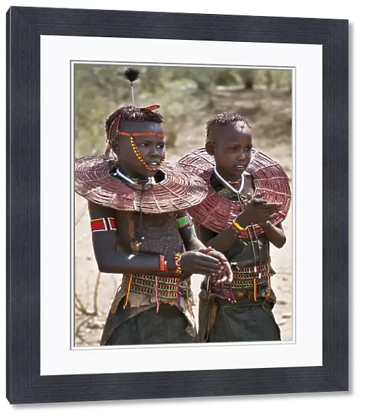 Two young Pokot girls wearing traditional ornaments that denote their unmarried status