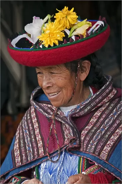 Peru, An old woman in traditional Indian costume with her round, saucer-shaped hat decorated with fresh