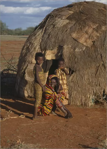 20070945. SOMALIA Gedo Woman and her two daughters outside their hut