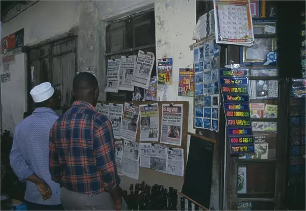 20005185. TANZANIA Zanzibar Stone Town. Two men at a newspaper stall