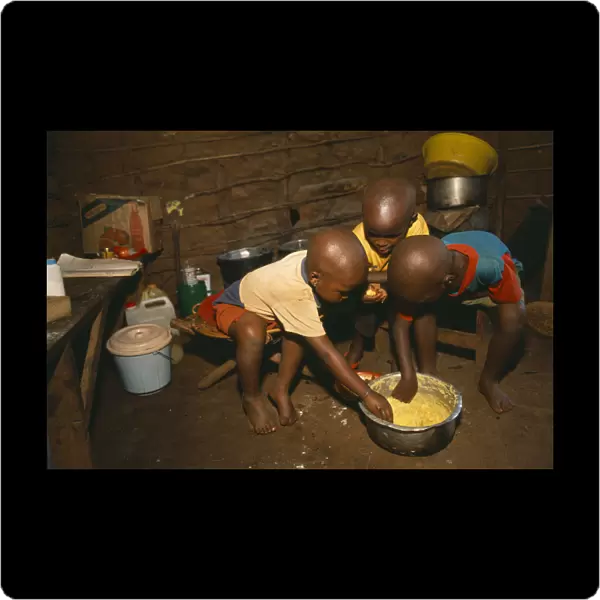 20062740. TANZANIA West Great Lakes Region Refugee children eating maize porridge