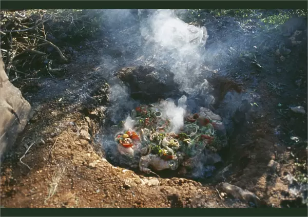 20066333. LIBYA Cyranaica Cooking meat on hot stones in a hole in the ground