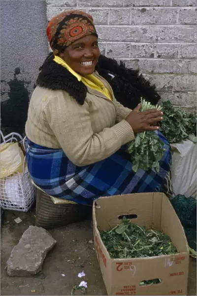 20075181. LESOTHO Maseru Woman at Maseru market selling greens from cardboard box