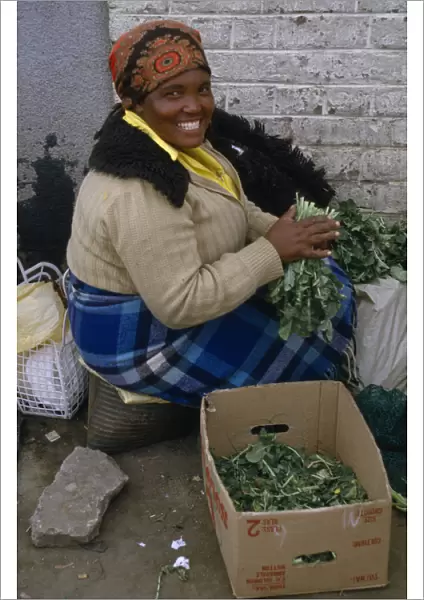 20075181. LESOTHO Maseru Woman at Maseru market selling greens from cardboard box