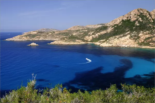 FRANCE, Corsica, Calvi, Turquoise waters & rugged coastline with boat near Calvi