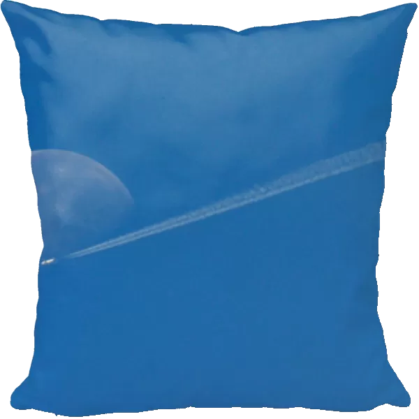 A plane flies in front of the moon