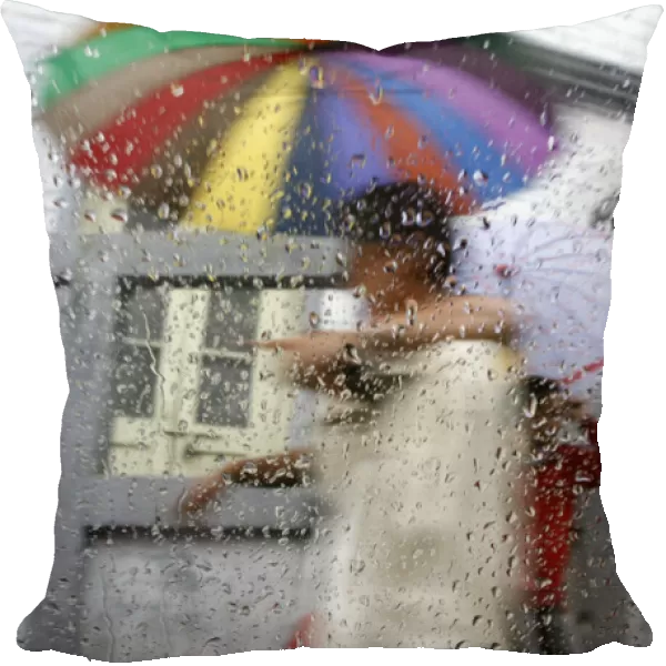 Pedestrians are seen through a car window during rainfall in Darjeeling